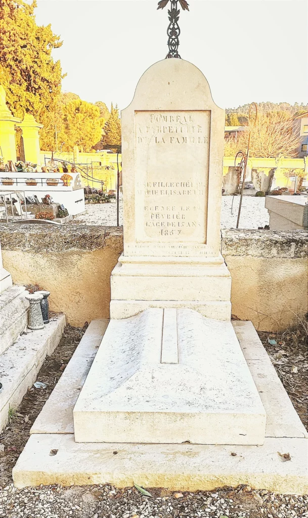 Sépulture ancienne en pierre claire rénovée avec stèle inscrite après nettoyage.