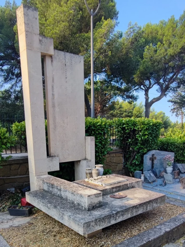 Monument funéraire contemporain en pierre couverte de salissures avant nettoyage.
