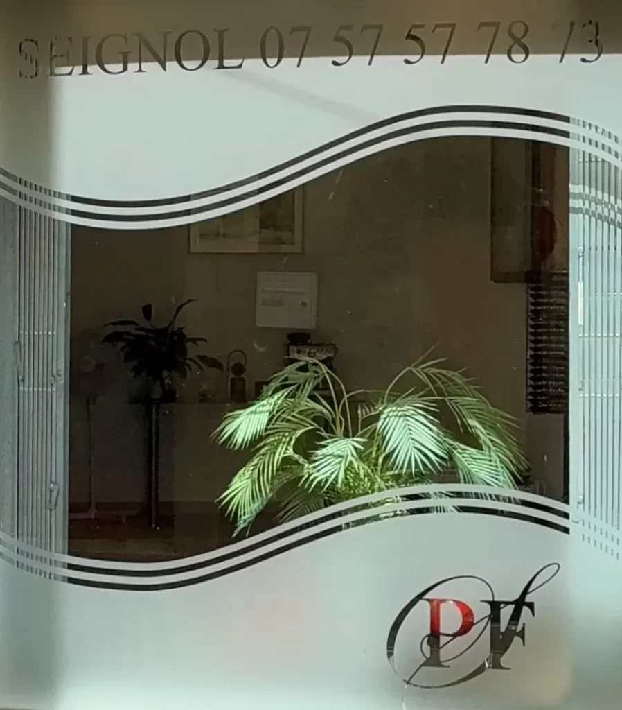 Vitrine d'agence de pompes funèbres avec lettrage et plante verte.